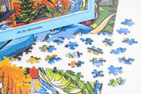 Partially assembled puzzle featuring colorful Minnesota-themed artwork, with loose pieces and the box lid visible on a white surface.