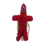 Small red felt doll with colorful thread details and a string on its side, inspired by Scandinavian Christmas decor, shown against a plain white background.