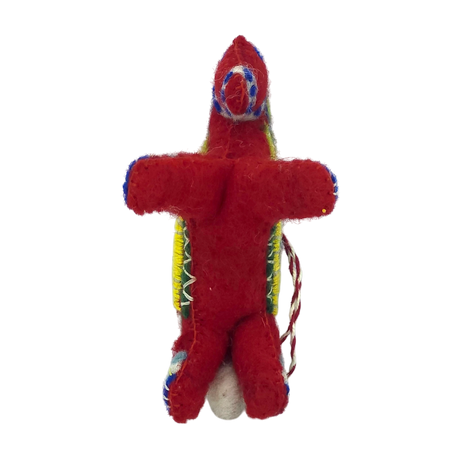 Small red felt doll with colorful thread details and a string on its side, inspired by Scandinavian Christmas decor, shown against a plain white background.
