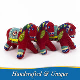 Two red Swedish Dala Horse ornaments with colorful painted details stand side by side on a white surface. Text below reads “Handcrafted & Unique.”.