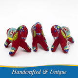 Three red felt ornaments shaped like Swedish Dala horses with multicolored embroidered patterns. A small tag with the words “Handcrafted & Unique” is attached to one ornament.