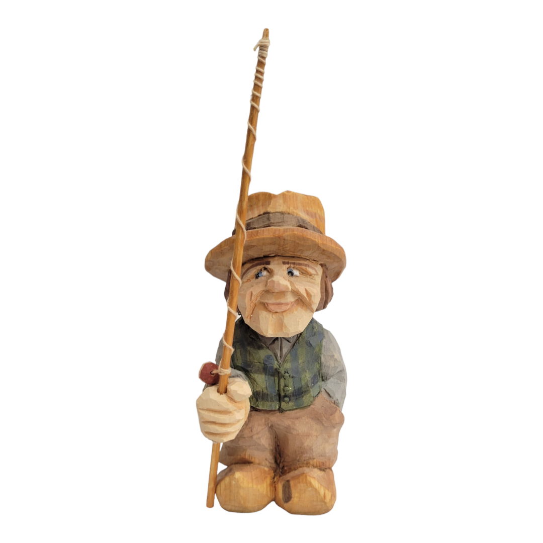 The "Fisherman" by Bill Erickson is a beautifully hand-painted, wood-carved figurine showing a person wearing a hat and holding a fishing rod, elegantly dressed in a green vest and brown pants.