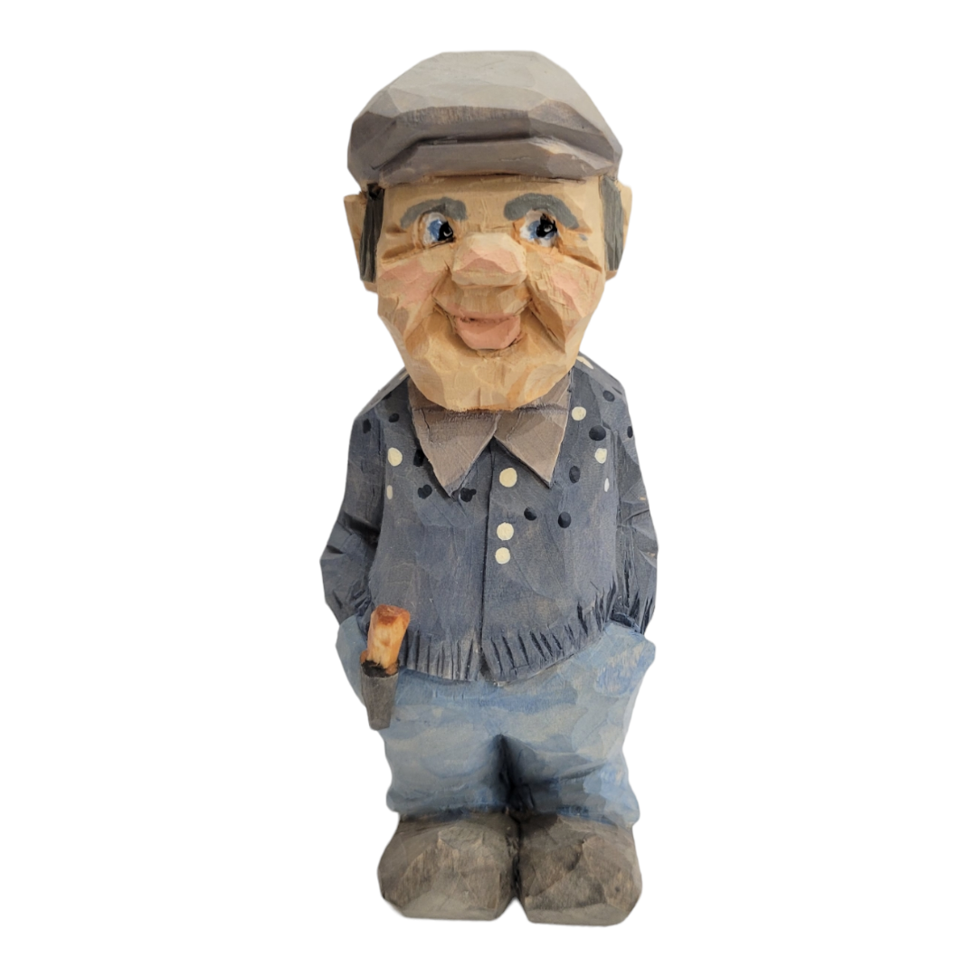 The delightful 6-inch wood carved figurine "Lars" by Bill Erickson showcases a smiling character in blue pants and a dotted shirt, holding a small object in one hand and wearing a cap.