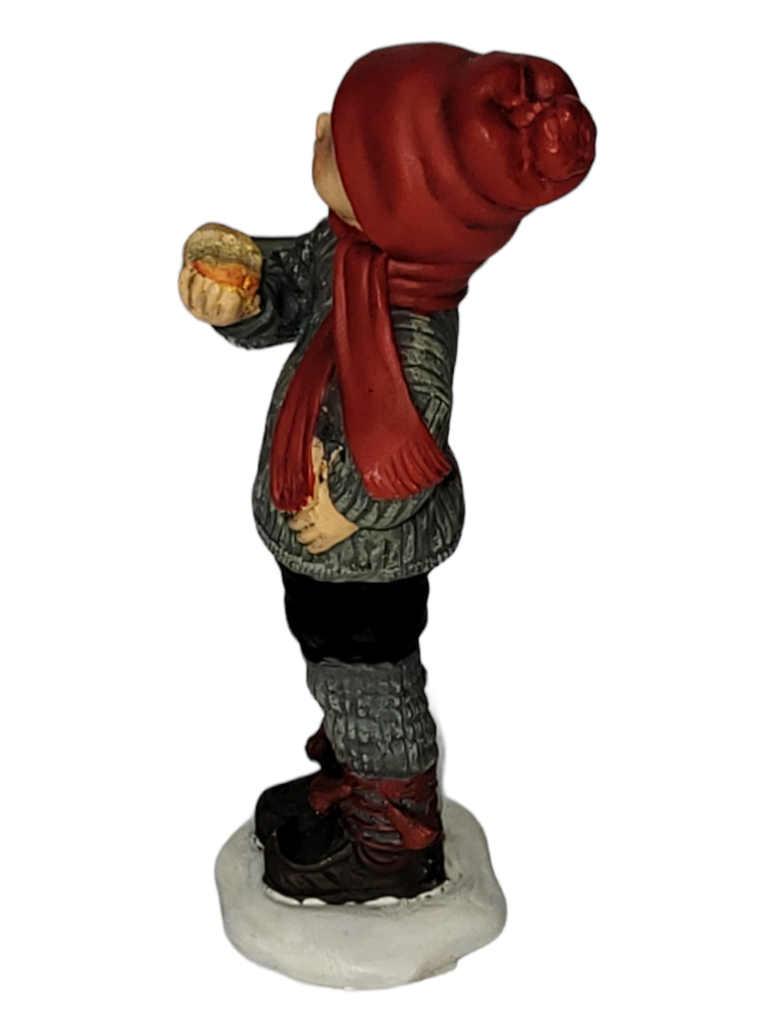 The "Apple Boy Large" figurine, inspired by Norwegian design, features a child in a red hat and scarf holding a muffin while standing on a snowy base.