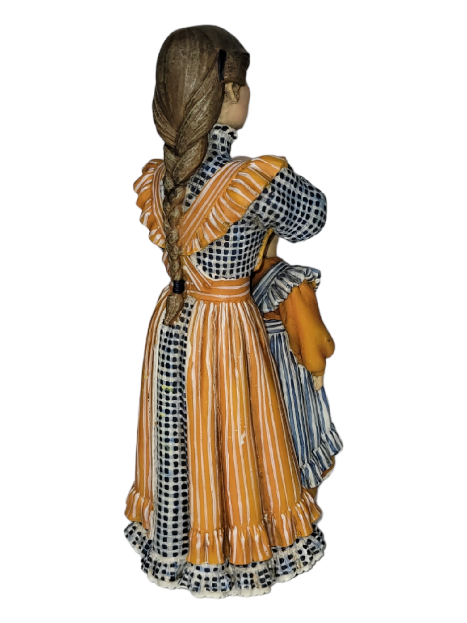 A figurine from the Mother & Daughter collection, inspired by Carl Larsson, featuring a girl with braided hair wearing a patterned dress with ruffled sleeves and an apron, holding a doll.