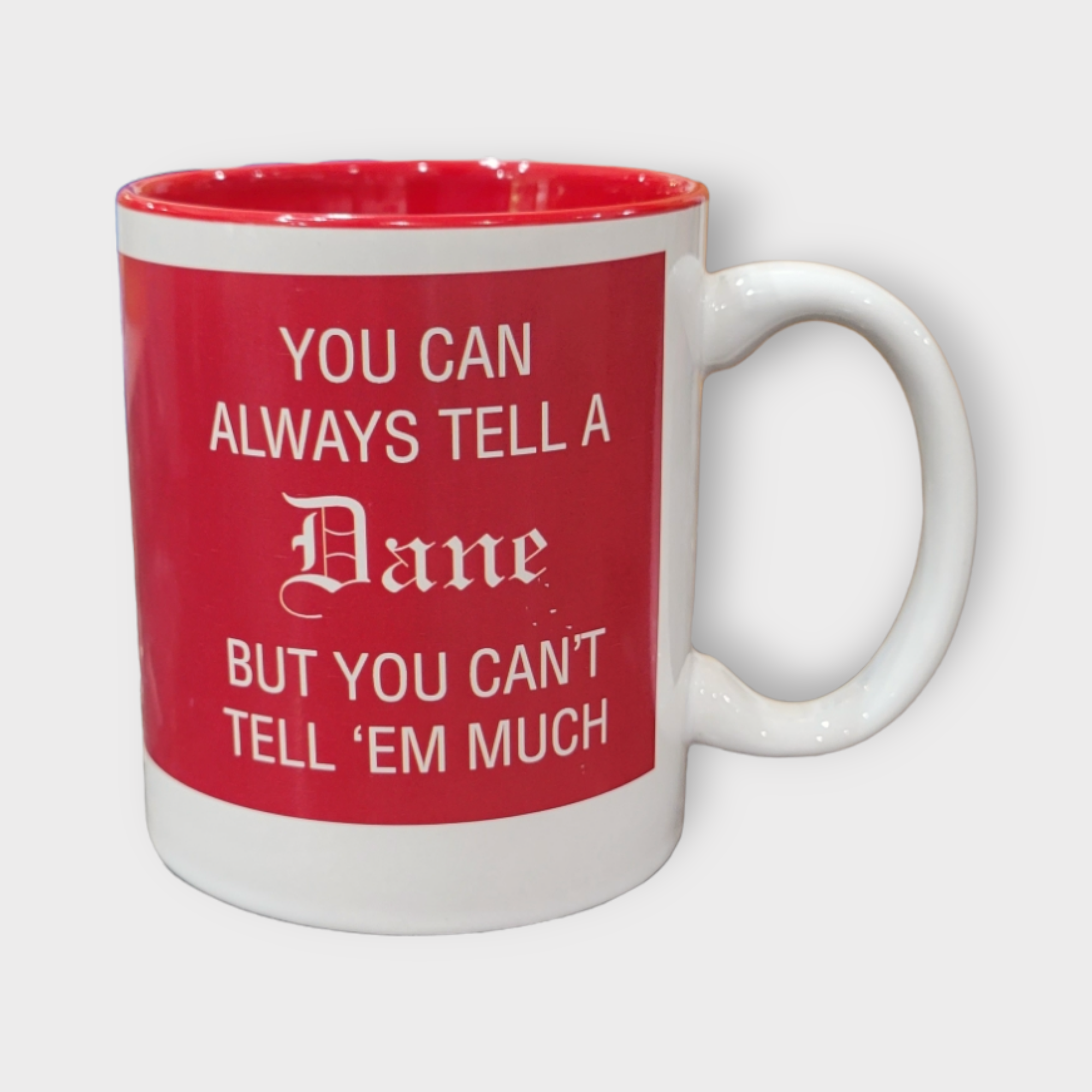 11oz white ceramic mug featuring a red interior and the phrase "You can always tell a Dane but you can't tell 'em much" in red text.