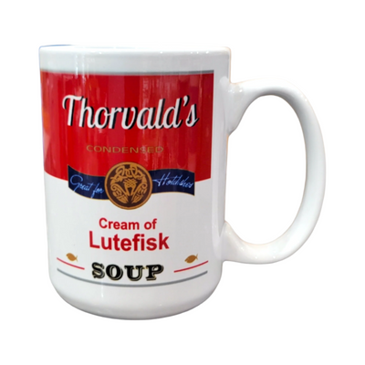 This 15oz ceramic mug, labeled Thorvalds Condensed Cream of Lutefisk Soup in a red and white can-like design, features small fish icons. Dishwasher-safe, it blends quirky decor with practicality.