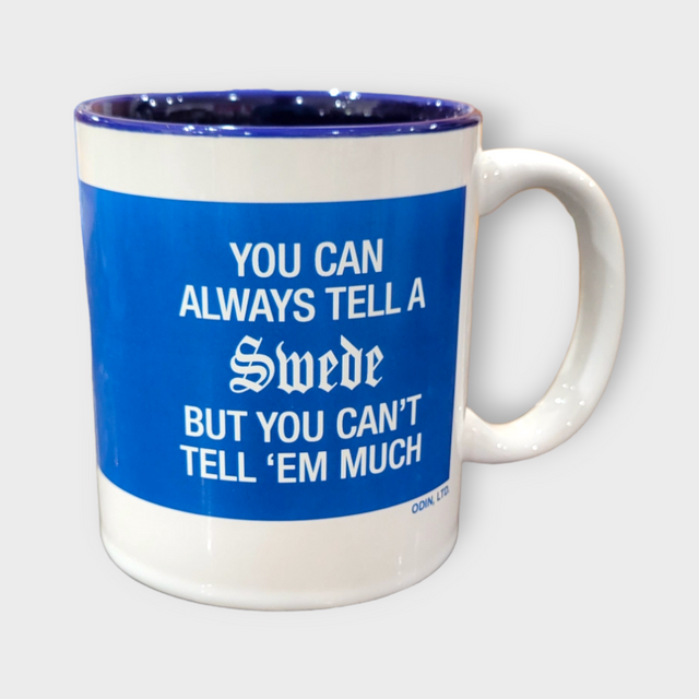 Enjoy your favorite hot drink in the 11oz Coffee Mug: You Can Always Tell A Swede But You Can't Tell 'Em Much, featuring a blue interior and witty saying on white ceramic.