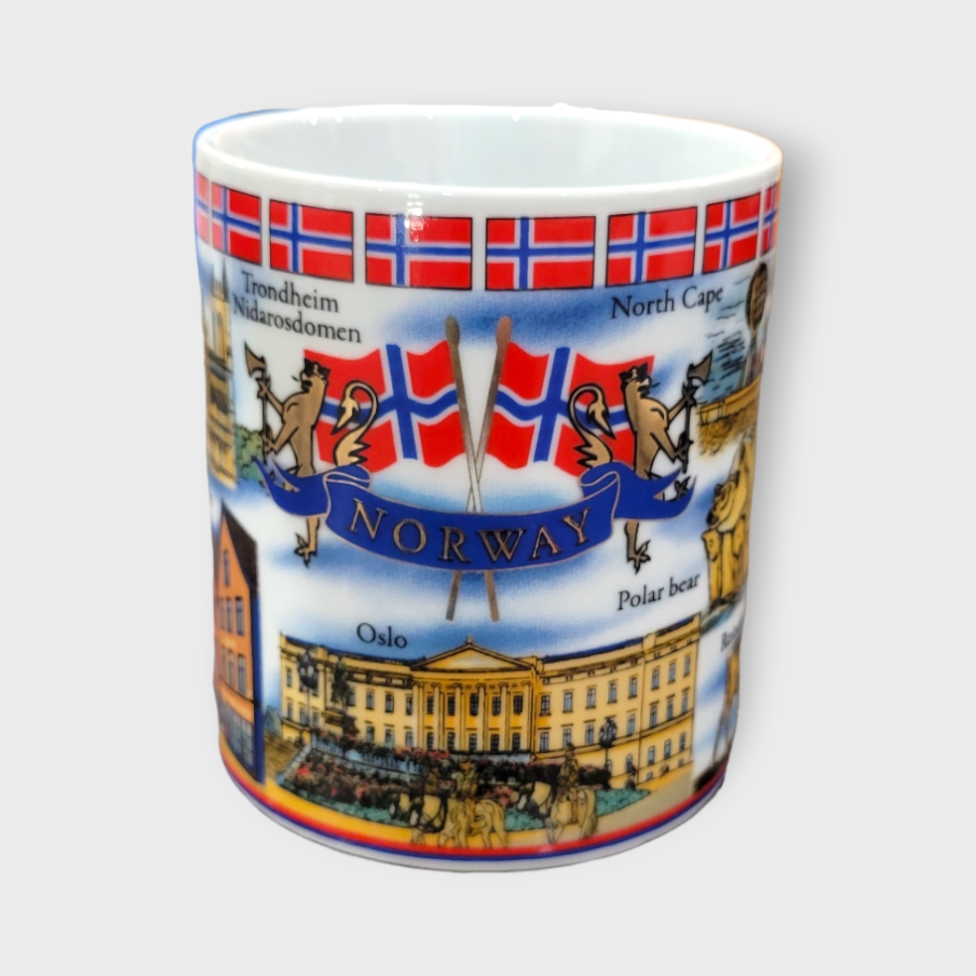 The "Norway" Scenery & Symbols 11oz mug vividly displays ceramic artistry with Norwegian landmarks and icons, featuring elements such as flags, polar bears, and city names like Oslo and Trondheim.