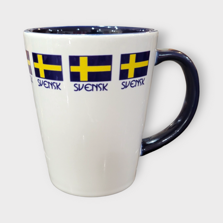 The Coffee Mug: "Svensk" Swedish Flag Latte Style (12oz) features a white body, dark handle, Swedish flag accents, and repeated "SVENSK" text near the rim—a perfect mug for enjoying your favorite brew.