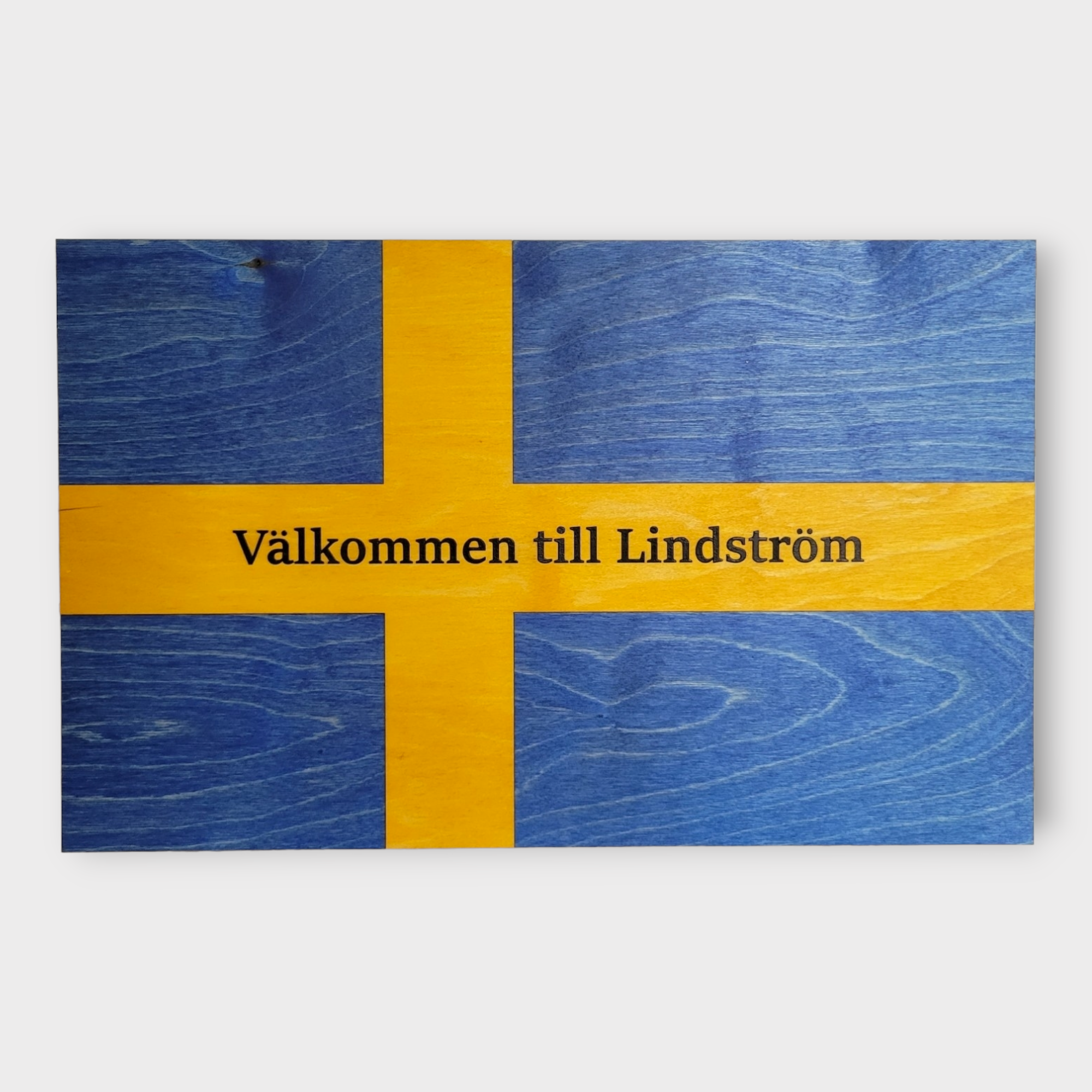 The "Novelty Signs: Valkommen Swedish Flag" is elegantly designed and features the text "Välkommen till Lindström," with dimensions of 10 inches by 16 inches.