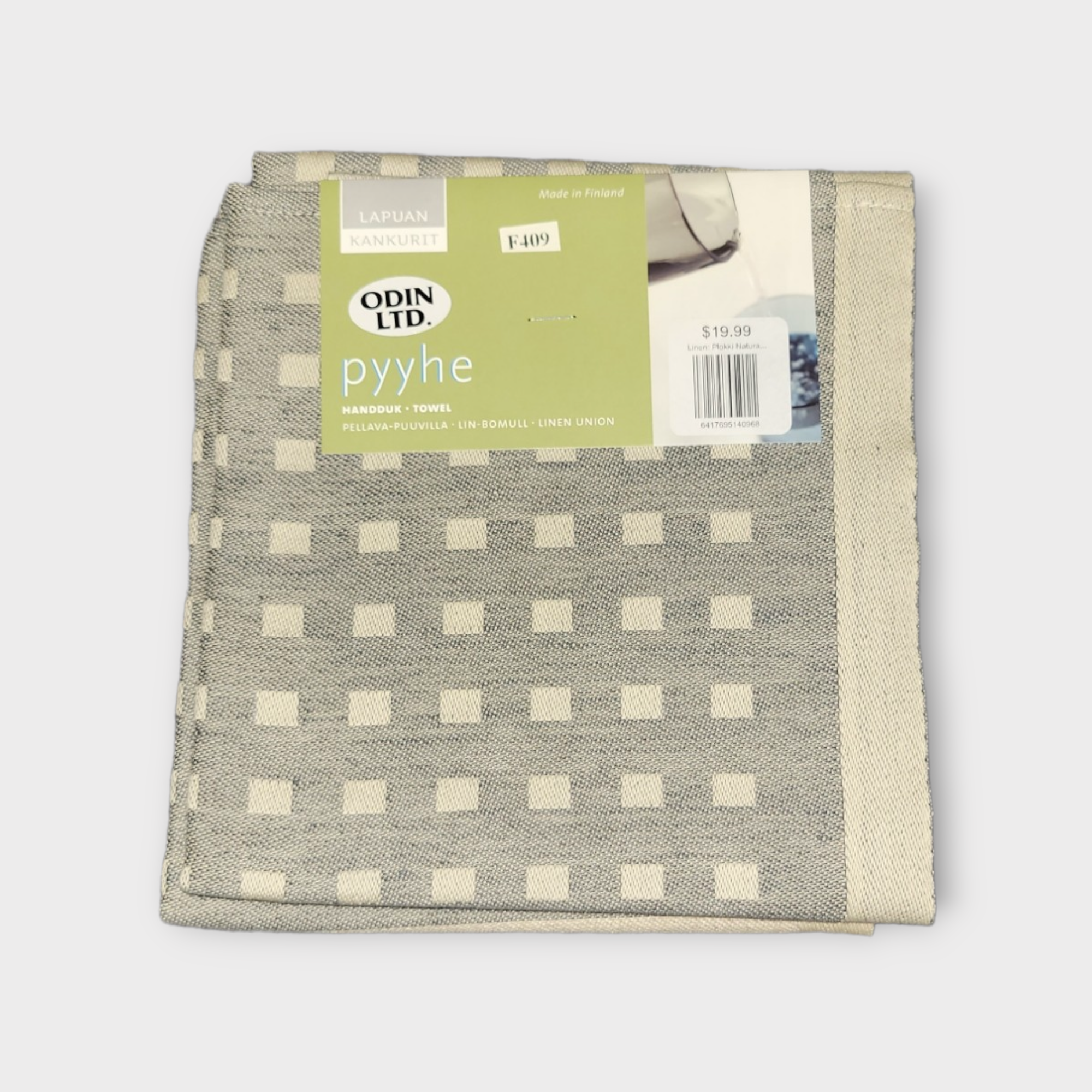 The Tea Towel: Linen Natural Squares is a beautifully woven gray and beige checkered towel, crafted from authentic Finnish linen. It features a label indicating its origin from Lapuan Kankurit in Finland. This exquisite towel is priced at $19.99.