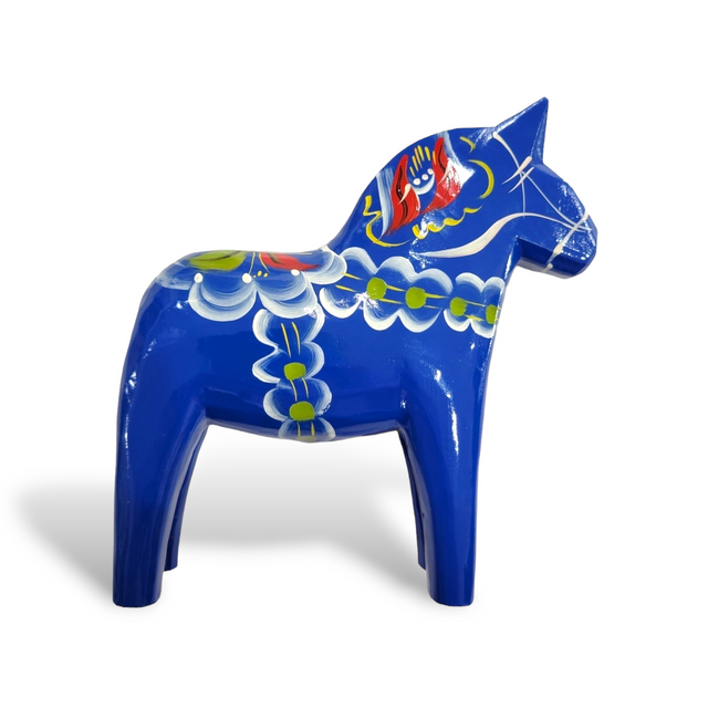The Royal Blue Swedish Dala Horse features intricate hand-carved details with vibrant white, green, and red floral patterns, exemplifying exquisite craftsmanship from Sweden.