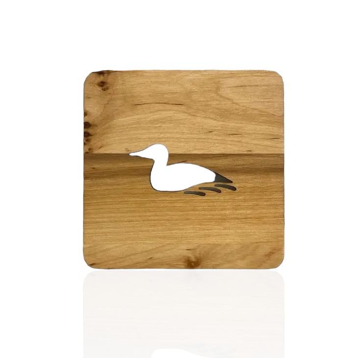 An Alder coaster crafted with a laser-cut silhouette of a loon, elegantly centered in the middle, named the Wood Loon Coaster.