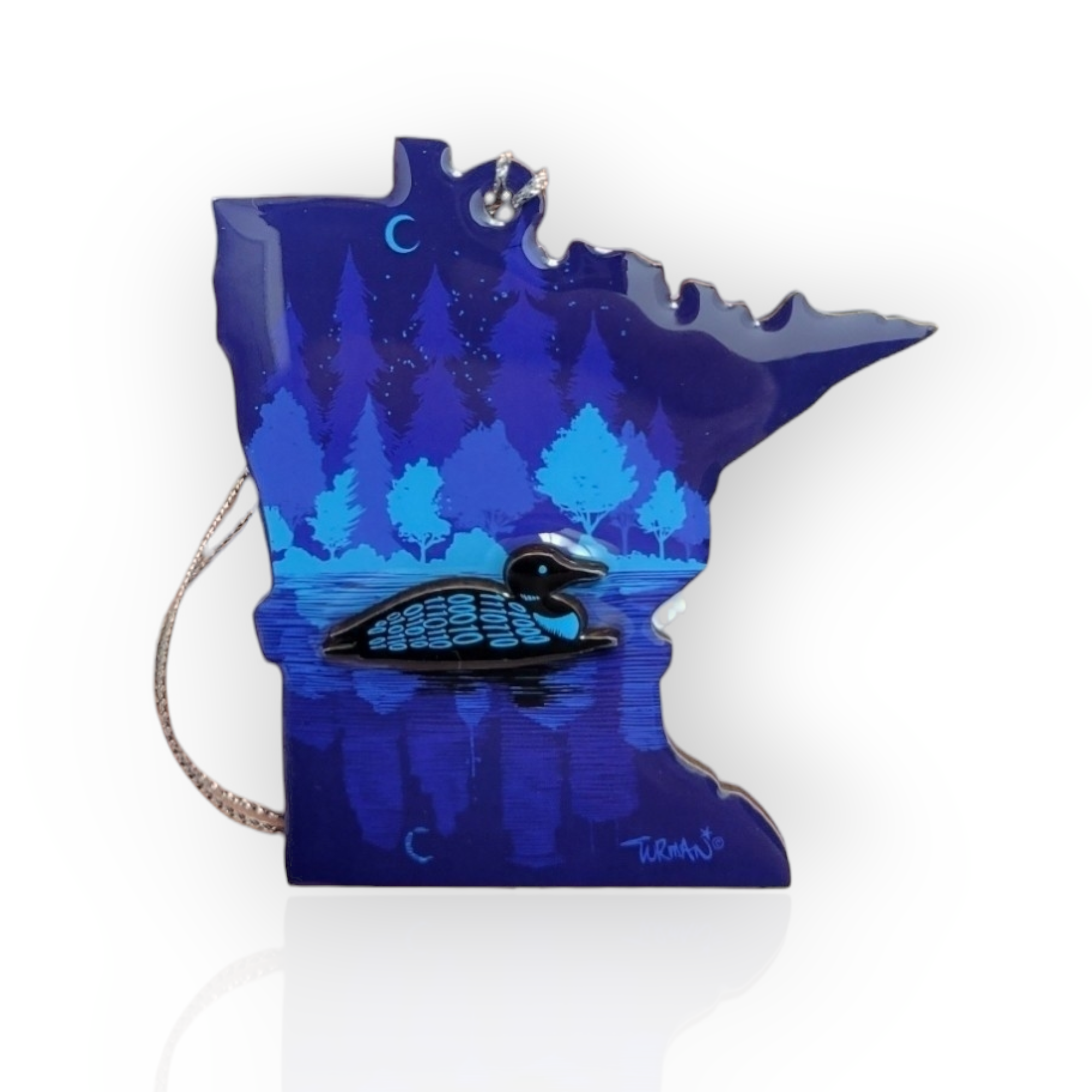 The "Ornament: Loon MN 3D" captures the enchanting essence of Midnight Loon artistry by showcasing a decorative display of Minnesota, featuring a loon on a lake surrounded by trees under a starry sky.