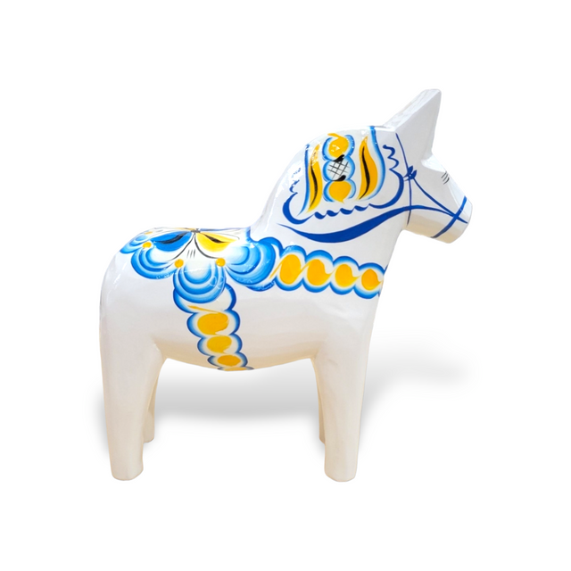 White Dala Horse from the Swedish Flag Series, featuring intricate blue and yellow kurbits patterns, facing left.