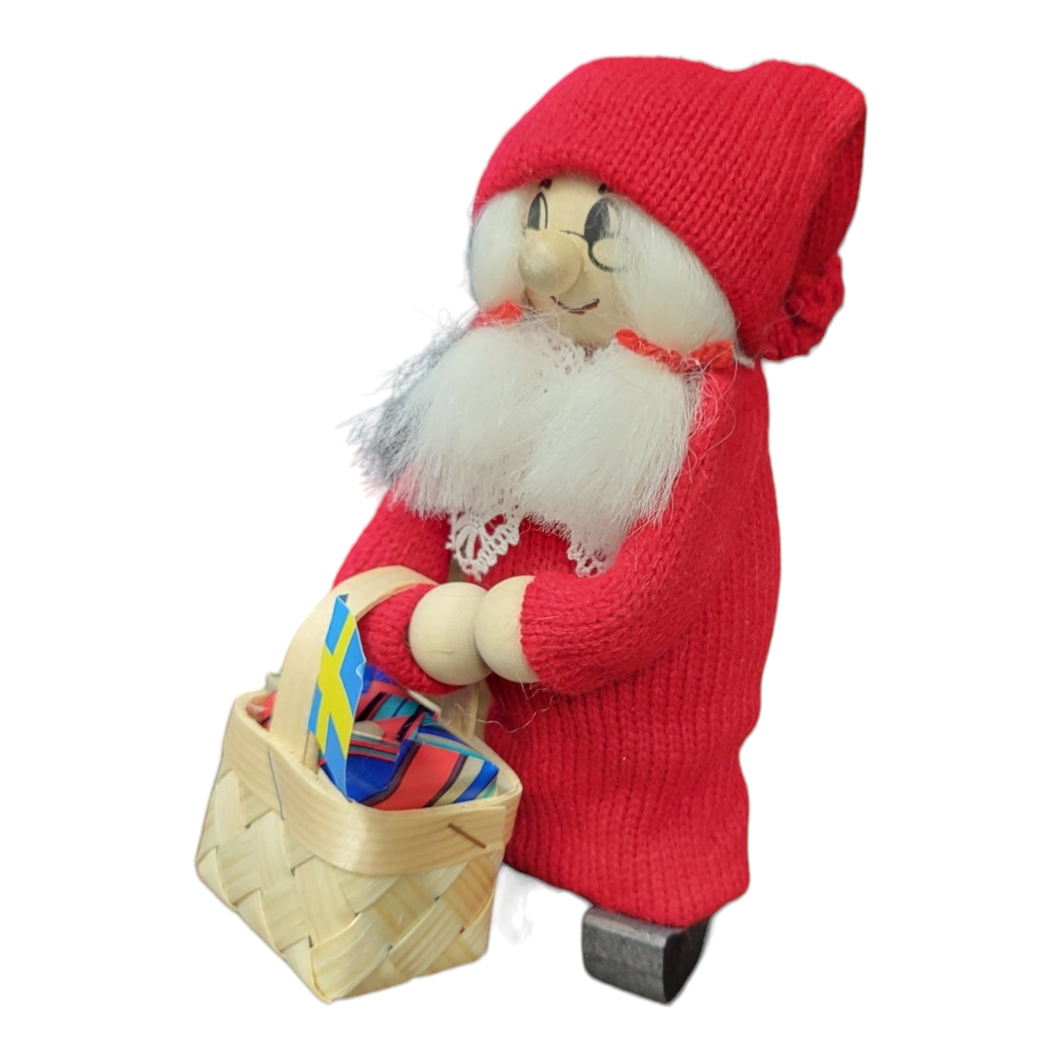 The Figurine: Swedish Handcrafted Santa Woman with Basket wears a red outfit and carries a basket filled with colorful paper.