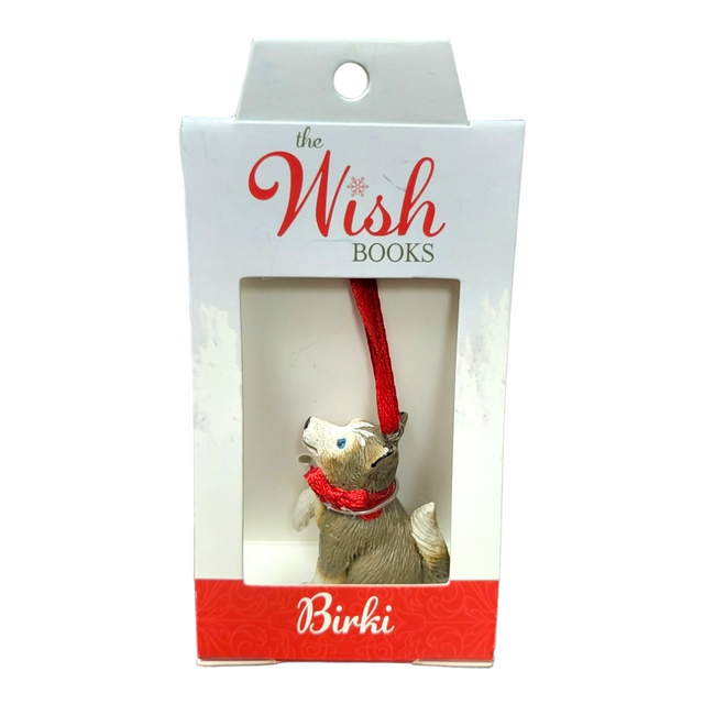 An ornament named Birki - Anja's Husky Puppy from The Wish Books, featuring a dog with a red ribbon nestled in a box, perfect for adding a touch of Christmas magic, as if crafted by Santa's Elves themselves.