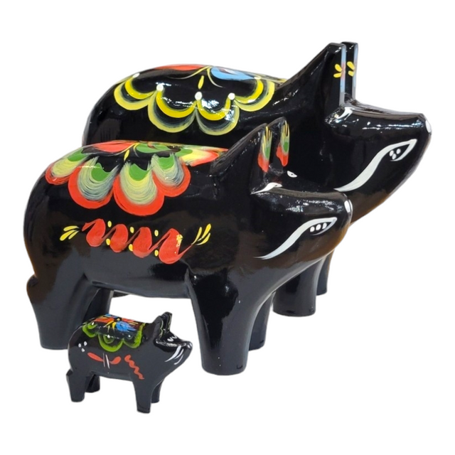 A set of three Dala Pigs: Black, each featuring colorful painted designs, is artfully arranged in decreasing size order, highlighting exquisite Swedish handcraft.