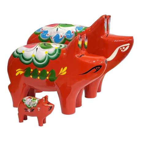 Three Dala Pig: Red pieces, skillfully crafted from pine wood and adorned with colorful painted designs, are arranged in a line as a charming example of Swedish handcraft.