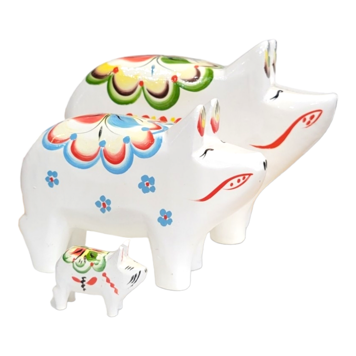 Three Dala Pigs: White, inspired by Swedish craftsmanship, showcase vibrant floral patterns and are organized in ascending order.