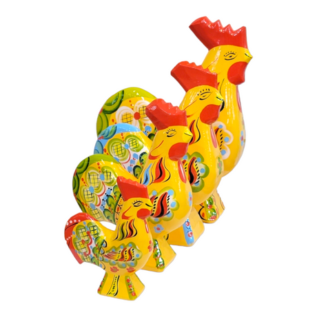 Four decorative ceramic Dala Roosters are arranged in a row, showcasing vibrant colors and intricate patterns with bright red crests inspired by Swedish traditional handcraft. These Yellow Dala Roosters add a touch of kurbits art to any setting.