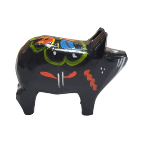 The Dala Pig: Black is a handcrafted wooden figurine featuring colorful painted patterns with details in green, blue, and red, reminiscent of traditional Swedish Dala pigs.