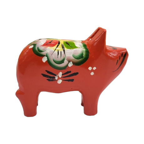 The Dala Pig: Red is a small, exquisitely handcrafted ceramic figurine, featuring floral and geometric patterns in green, yellow, and black on a painted red finish. Reminiscent of traditional Swedish handcraft, this piece captures the charm of iconic Dala pigs.