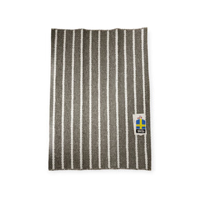 A woven vinyl rug named Horredsmattan - Music - Dark Gray featuring black and white stripes and a tag with the Swedish flag.
