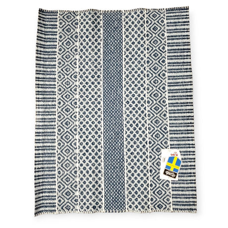 The Horredsmattan Alfie Blue vinyl rug features an elegant patterned blue and white design with two tags in the bottom right corner, showcasing Swedish style.