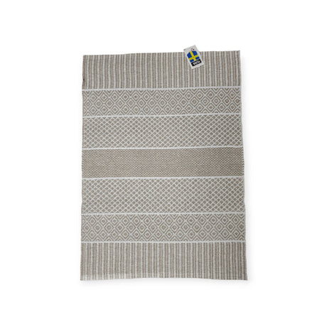 The Alfie vinyl rug by Horredsmattan in sand features a geometric pattern, beige and gray tones, an eco-friendly PVC blend, and a Swedish flag tag.