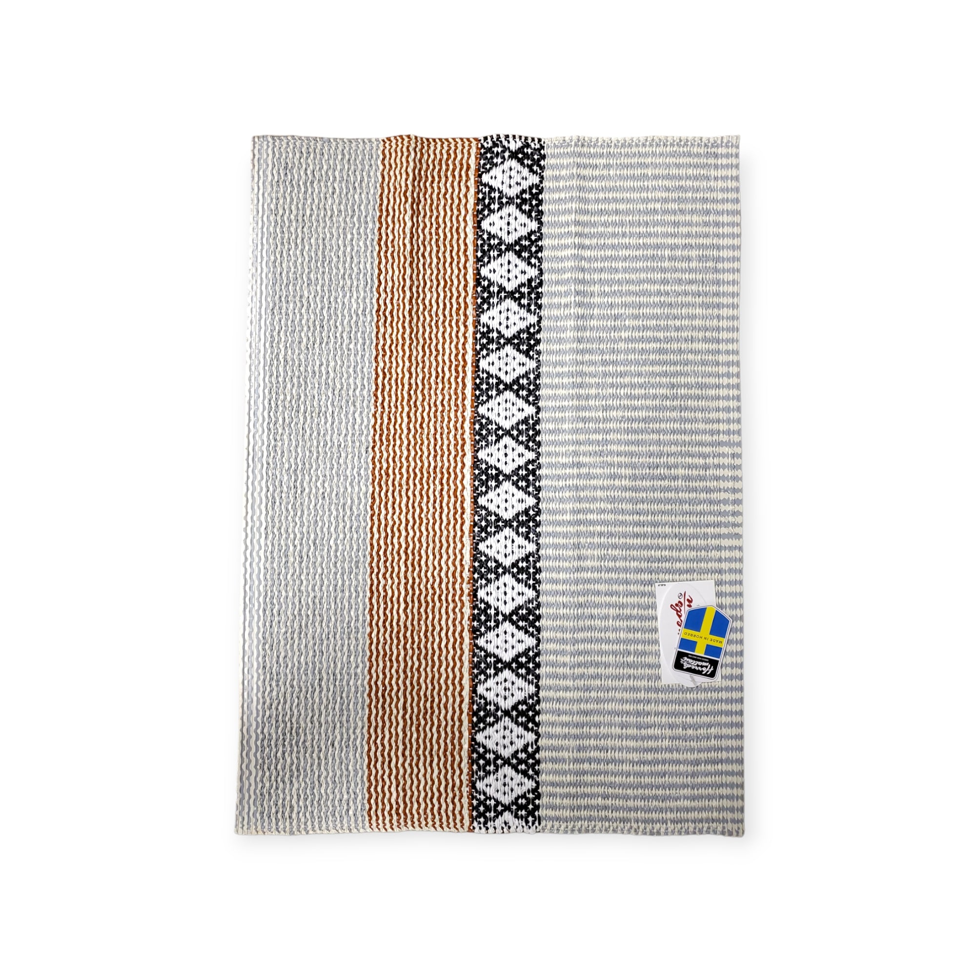 A rug with vertical stripes in gray, tan, and black patterns, featuring a Horredsmattan Swedish-themed tag in the corner, named Rug: Savanne Light Grey Vinyl.