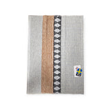 A rug with vertical stripes in gray, tan, and black patterns, featuring a Horredsmattan Swedish-themed tag in the corner, named Rug: Savanne Light Grey Vinyl.