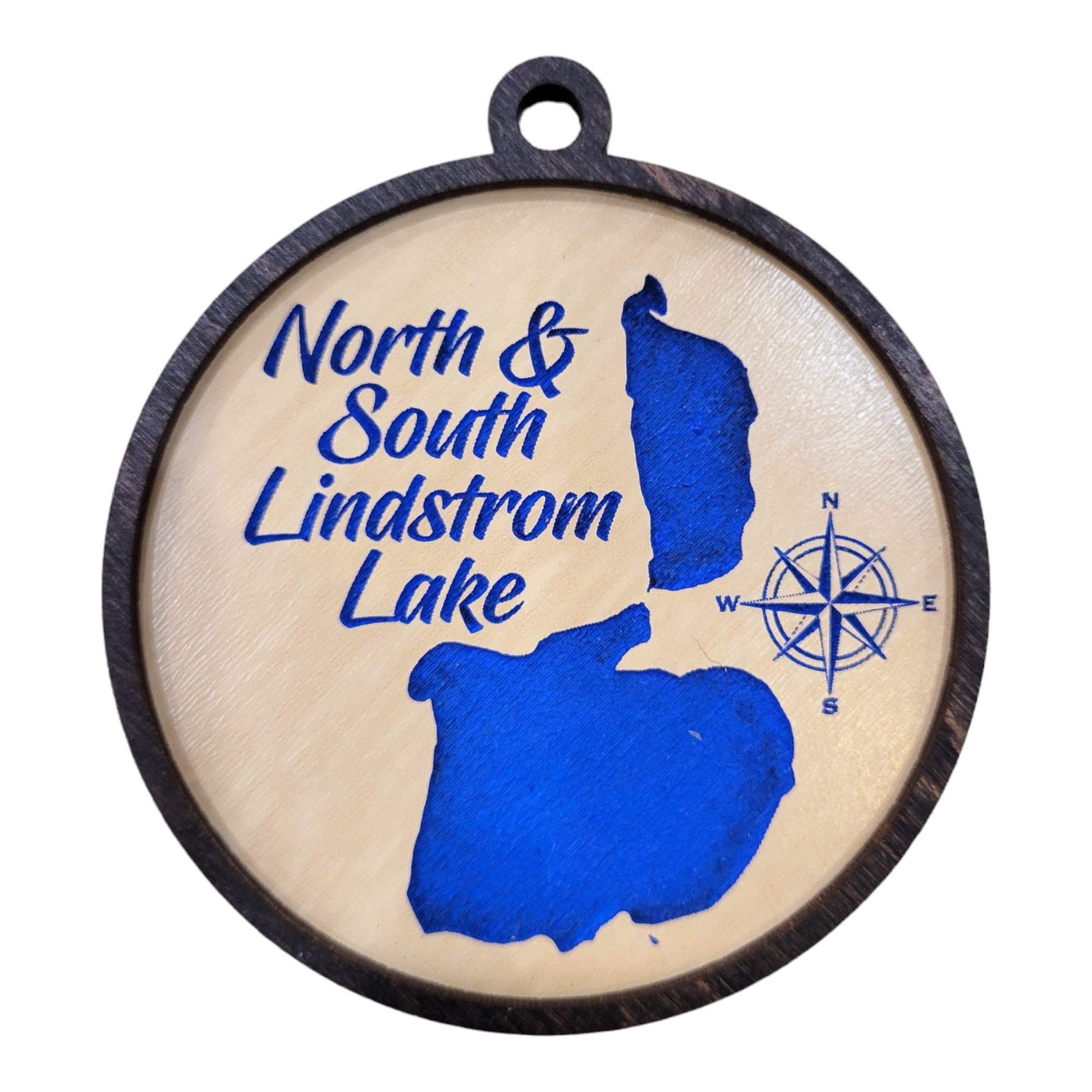 The Ornament: North & South Lindstrom Lake - Round Etched Wood is a 3 1/2-inch circular piece crafted from wood, featuring an etched map silhouette of North & South Lindstrom Lake in blue, complete with a compass rose and text reading "North & South Lindstrom Lake.