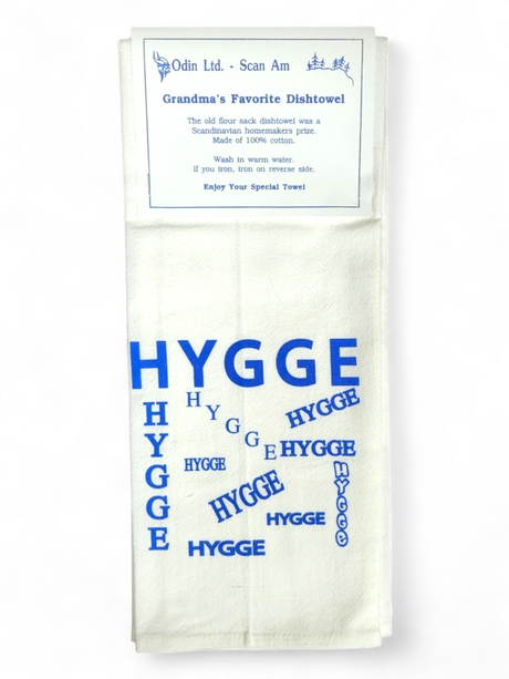 Introducing the "Hygge" Grandma's Favorite Dishtowel, a Scandinavian handmade white kitchen tea towel featuring the word "Hygge" in blue. Crafted from 100% cotton, it's available in multiple sizes. Care instructions: wash in warm water and iron while damp.