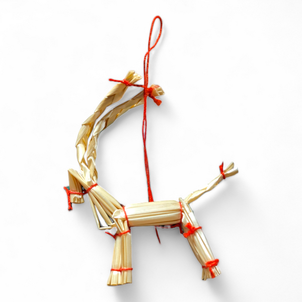 The Ornament: 3” Straw Goat Yulbok Christmas Tree Ornament is a handcrafted piece tied with red string, adding a whimsical twist to traditional Scandinavian holiday décor.