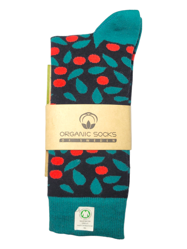 A pair of socks with a red and green leaf pattern, wrapped in a brown label that reads “ORGANIC SOCKS OF SWEDEN.”.