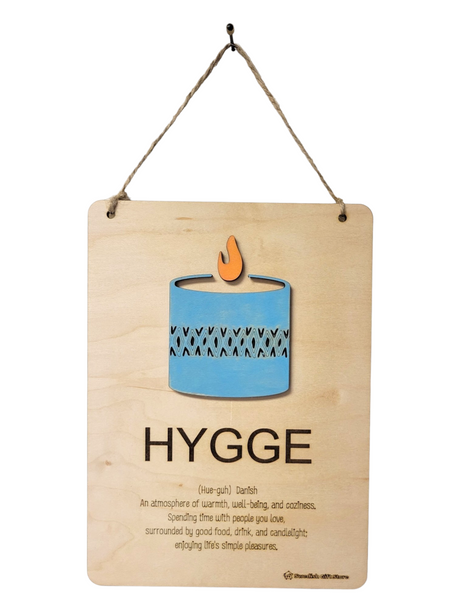 The Hygge Wooden Wall Plaque (5¾" × 8") features a laser-cut candle motif and the Danish definition of “hygge”—coziness, warmth, and enjoying life’s simple pleasures—making it perfect for Scandinavian-inspired home décor.