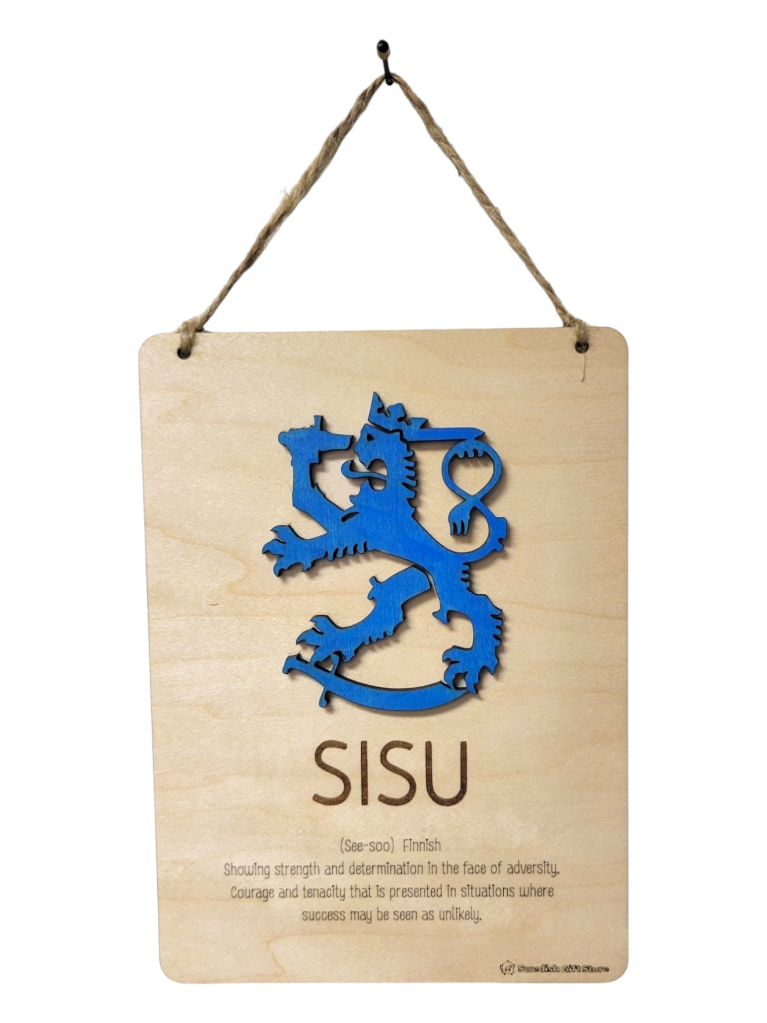 A sign titled "Sign: Sisu Definition," featuring a blue lion emblem and the word SISU in bold, is adorned with a wooden plaque. It showcases the definition of SISU—resilience and courage—and hangs from a twisted rope, symbolizing strength and determination.