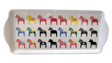 The Tray: Multi Color Swedish Dala Horses Almond Cake or Serving Tray features rows of colorful Dala horse silhouettes in red, yellow, green, blue, and black. Made from durable melamine plastic, it is both functional and visually striking.