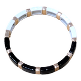 A bracelet from A&C Oslo called "Black/White Enamel Tile," features alternating enamel tiles and rectangular beads with the brand's signature gold accents.