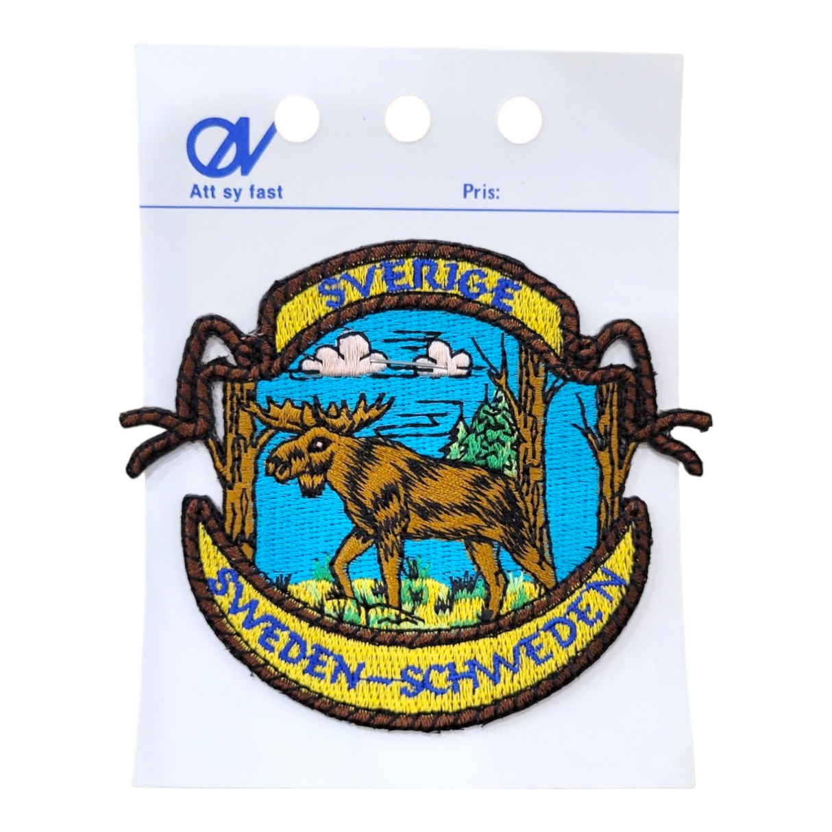 Patch: Sverige - Sweden - Schweden with a Moose Walking in the Woods Embroidery Patch—features a moose, trees, and clouds; perfect Sweden souvenir, on display card with holes at the top.