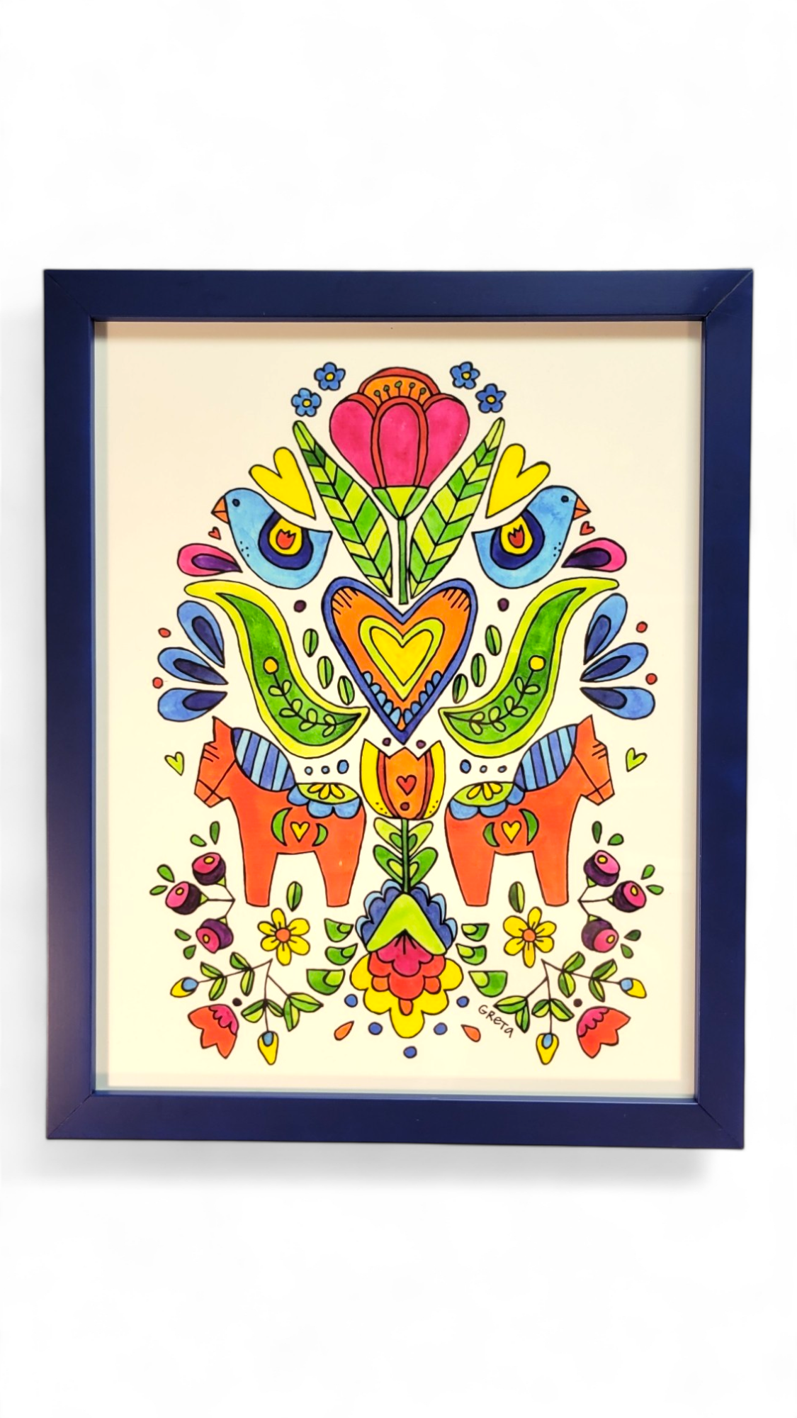 Introducing the "Spring Folk Horses" by Greta Lann Framed artwork, a captivating addition to any space. This vibrant watercolor print features symmetrical floral and animal motifs framed in blue. The delicate folk flowers and horses enhance its charm and richness, making it a compelling folk art piece.