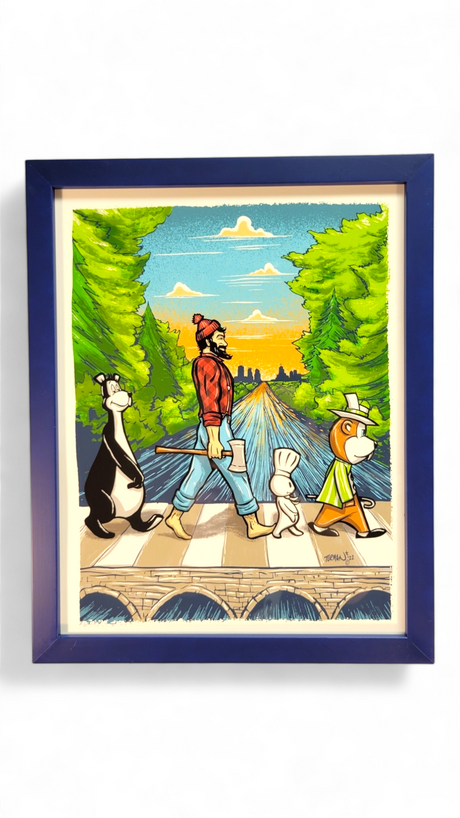 Framed artwork titled Abbey Road 11x14 by Adam Turman Print, showcasing a man and three animals crossing a bridge amid Turmans colorful landscape with vibrant trees and a flowing river.