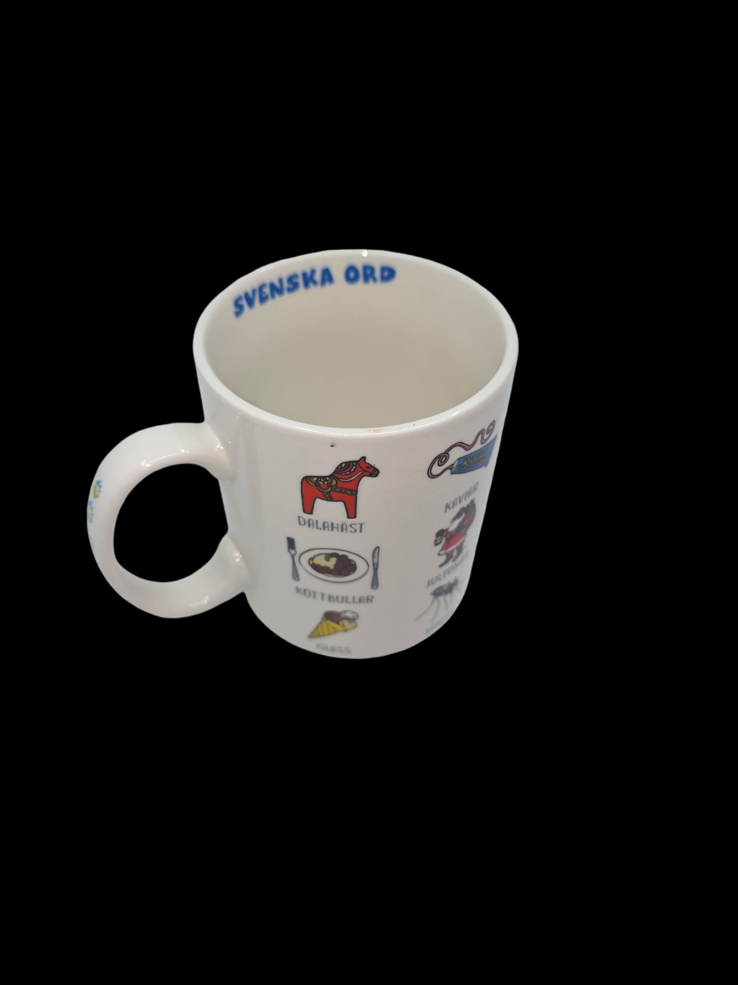 The "Mug: Swedish Words" is an imported latte mug from Sweden that showcases Swedish words and images, such as a red Dala horse and a waffle labeled 'våffla.' Inside, it features the text "SVENSKA ORD," while its sleek black background adds to its unique style.