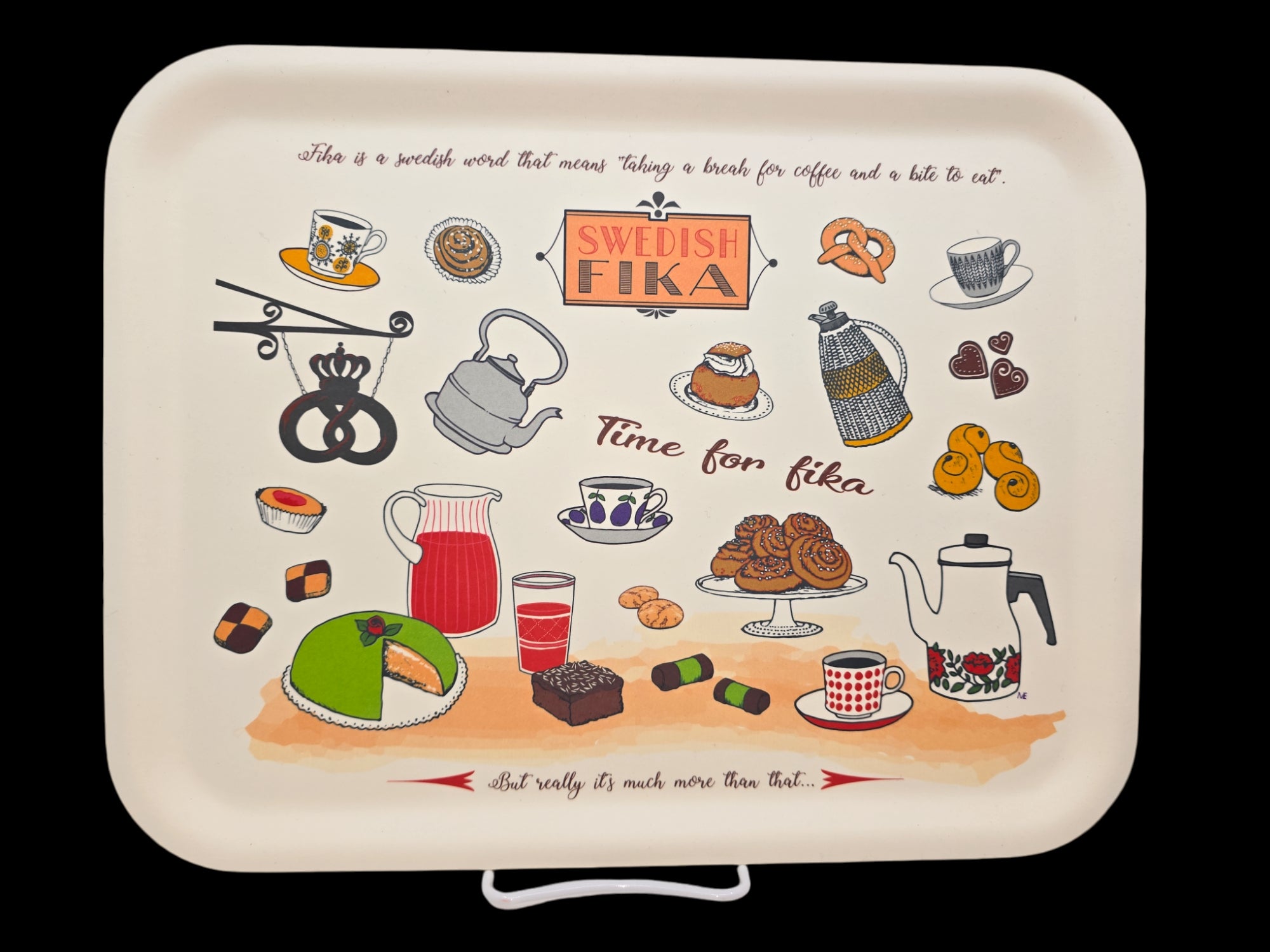 The "Tray: SWEDISH FIKA" is a beautifully illustrated wooden serving tray showcasing iconic Swedish fika elements like coffee, pastries, and text. Imported from Sweden, it features charming details such as cups, a teapot, cake, and traditional Swedish treats.