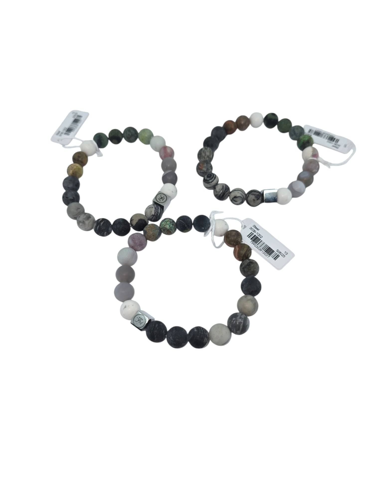 A set of three unisex bracelets, known as "Bracelet: Pure Steel Unisex Brown Tones," showcases a stretchy beaded design in Nordic-inspired shades of brown and gray, each accompanied by a tag and elegantly arranged on a white background.