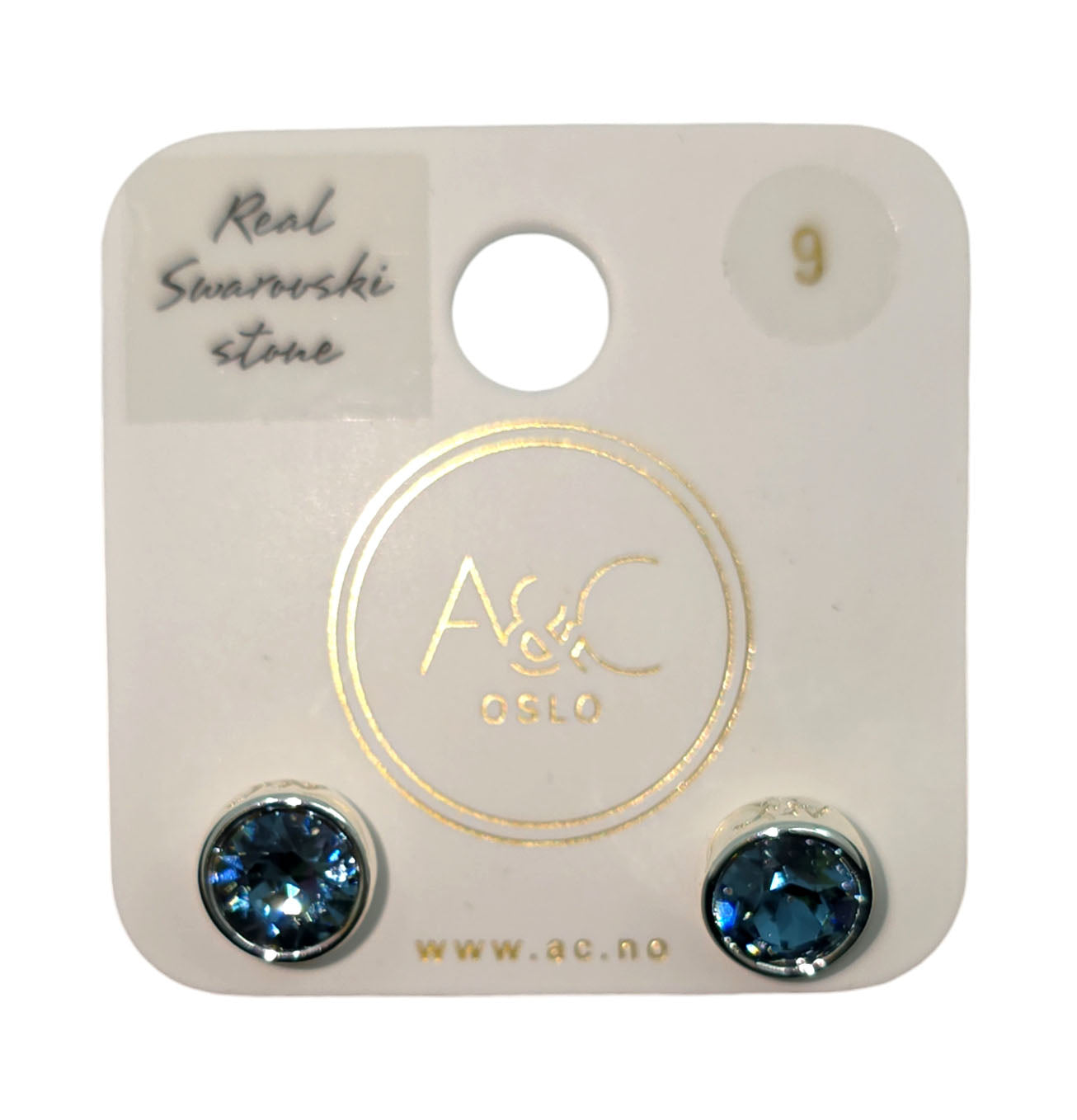 A pair of stunning A&C Norway Swarovski crystal earrings in denim blue, reminiscent of Norwegian nature, elegantly displayed on a white card from A&C Oslo.