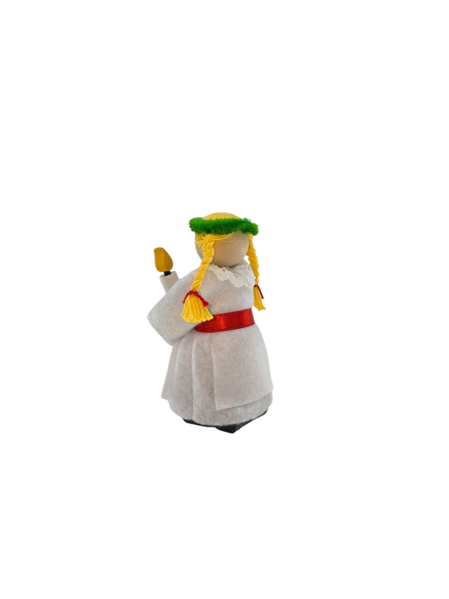 The Figurine: St Lucia Hand-crafted Wood Figurine, standing approximately 5 inches tall, is a small wood carving adorned in a white robe with a red belt and a green wreath on its head, holding a candle. This delightful piece celebrates the St Lucia Christmas holiday tradition.