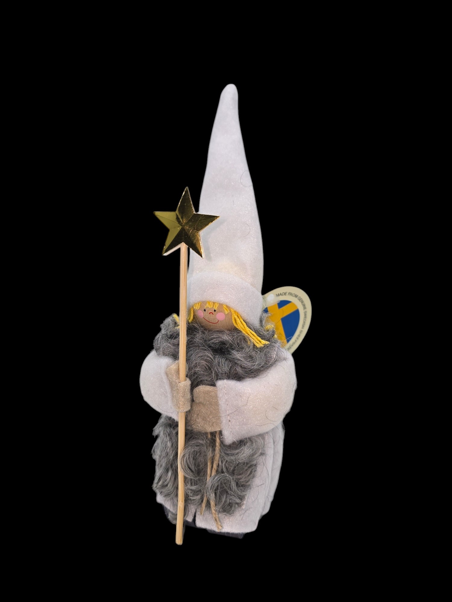 The "Staffan Stalledrang Star Boy" figurine, inspired by Scandinavian culture, features a gnome wearing a tall, pointed white hat and holding a gold star-tipped wand. It complements its look with a gray beard and white robe, capturing the charm of the classic Dala Figurine.